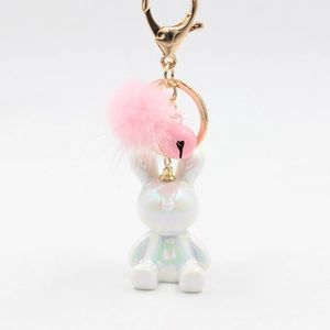 Detail of bunny keychain with iridescent resin coating, pink faux fur ball and heart bell