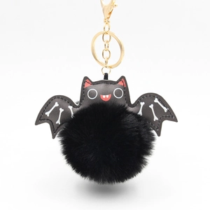 Detailed close-up of a plush bat keychain with soft faux fur and white bone wing patterns