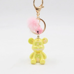 Pearlescent yellow resin bear keychain with pink faux fur pompom and metal bell