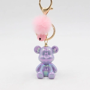 Metallic purple bear keychain with pink fur pom-pom and bell on gold keyring