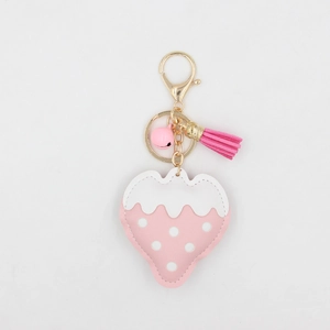 Détail du porte-clés fraise avec pompon rose, clochette et mousqueton doré