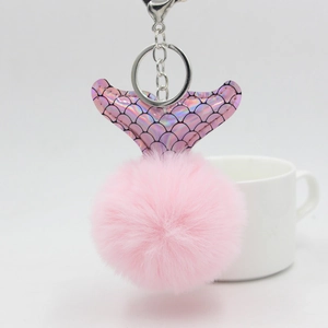 Vue détaillée du porte-clés pompon queue de sirène rose avec écailles irisées et métal