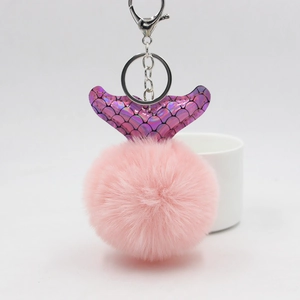Détail d'un porte-clés en peluche rose avec queue de poisson violette et fermoir argenté