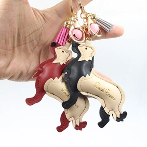 Detail of cartoon Golden Retriever leather keychain with colorful tassels and a pink bell