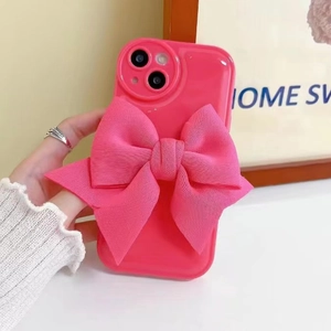 Detailed close-up of a pink phone case with a large 3D fabric bow accessory