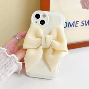 Close-up of white fabric bow phone case with soft 3D texture and elegant aesthetic