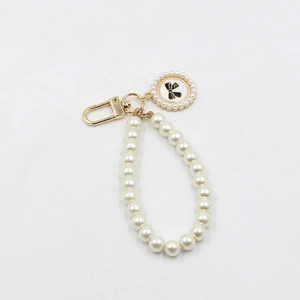 Vue détaillée du porte-clés en perles avec fermoir doré et pendentif rond à nœud noir