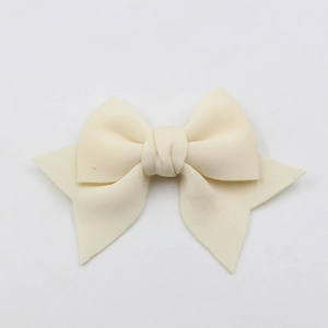 Close-up of a handmade beige fabric bow accessory for phone cases and shoes