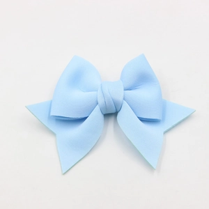 Macro shot of light blue bow accessory made of textured fabric for shoes and bags
