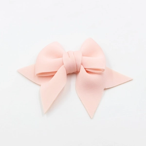 Detail view of light pink fabric bow charm with fine texture for shoes and bags