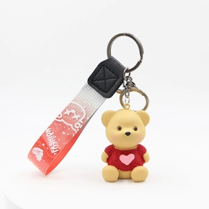 Cartoon teddy bear keychain with red sweater and pink heart on gradient strap
