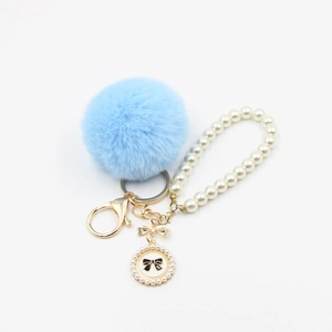 Blue faux fur pompom keychain with pearl wristlet and gold bow pendant for bags