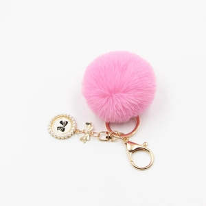 Pink faux fur pompom keychain with pearl bow pendant and golden clasp for bags