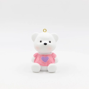 Detail of cartoon bear keychain featuring pink knitted sweater and purple heart pattern