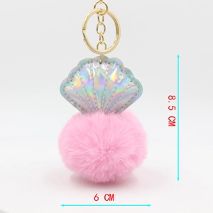 Detailed size view of pink faux fur pompom keychain with holographic shell accent