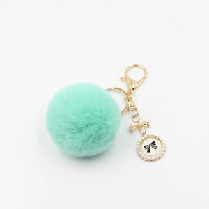 Mint green faux fur pompom keychain with gold bow and pearl perfume bottle tag