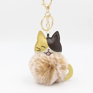 Détail d'un porte-clés chat tricolore avec pompon en fausse fourrure et fermoir doré
