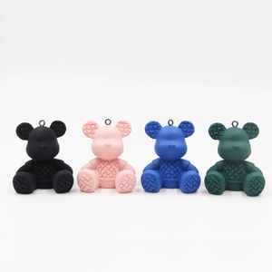 Detail showing colorful resin bear charms with woven texture and metal ring attachments