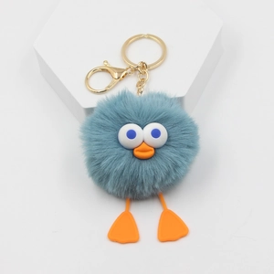 Détail du porte-clés canard en peluche bleue avec fermoir mousqueton doré sur socle