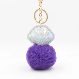 Detail of purple faux fur pompom and holographic shell keychain with gold metal clasp