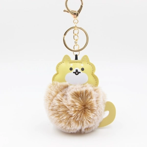 Detailed view of cute dog keychain featuring a fluffy faux fur ball and golden metal clip