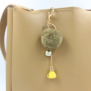 Portachiavi con pompon marrone, nappa gialla e campanellino argento appeso a borsa in pelle