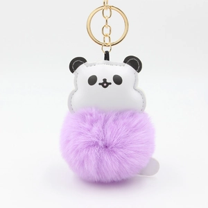 Detail of cute panda keychain featuring a purple faux fur ball and gold metal ring