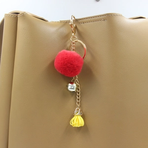 Portachiavi in peluche con pompon rosso, campanellino argento e nappa gialla