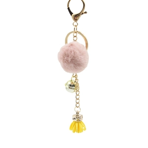 Portachiavi con pompon rosa campanellino dorato e nappa gialla su sfondo bianco puro