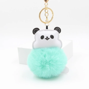 Detail of cute panda plush keychain with mint green fur ball and golden alloy ring
