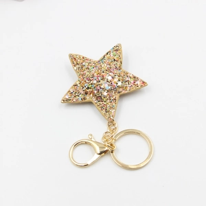 Détail d'un porte-clés étoile à paillettes avec fermoir mousqueton doré brillant