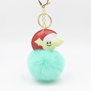 Detail of mint green plush ball keychain with red disc and yellow bat pendant
