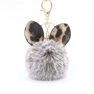 Detail of grey plush faux fur keychain with leopard print ears and golden lobster clasp