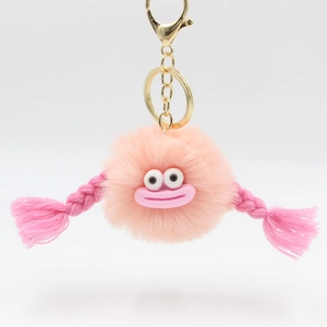 Cute pink plush monster keychain with large mouth and braided tassels for bags