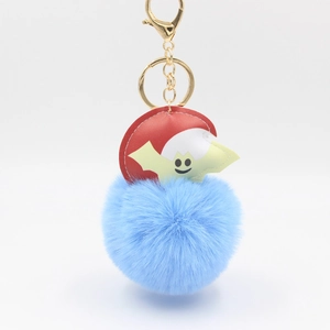 Detail of light blue pom-pom keychain with red bat leather charm and golden hardware