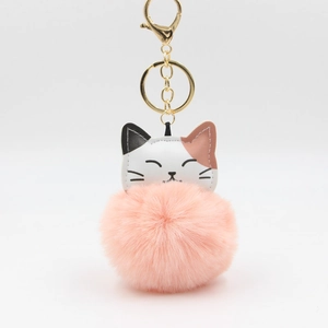 Detailed close-up of fluffy pink pom pom with tri-color leather cat face keychain charm