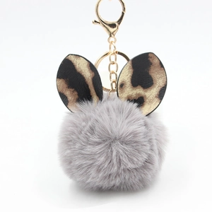 Close-up of fluffy grey faux fur keychain with leopard print rabbit ears and gold clasp