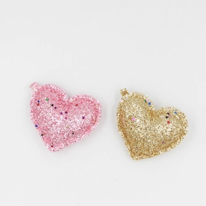 Détail de patchs en forme de cœur à paillettes roses et dorées pour loisirs créatifs