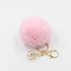 Detailed close-up of pink faux fur pompom keychain with golden crystal drop pendant