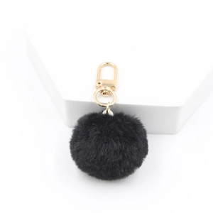 Close-up of 4cm black plush faux fur pompom keychain with a gold-tone lobster clasp