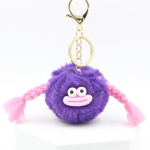 Close-up of cute purple fluffy ball keychain with pink big lips and braided pigtails detail