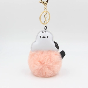 Detail of pink faux fur pompom keychain with white PU leather cartoon bird and gold clasp