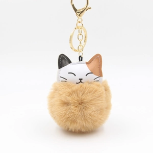 Close-up of a tricolor lucky cat plush pompom keychain with golden metal lobster clasp