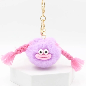 Macro view of purple fuzzy monster keychain with pink braids and golden metallic clasp