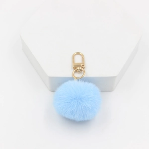 Detail of 4cm light blue faux fur pompom keychain with a polished gold lobster clasp