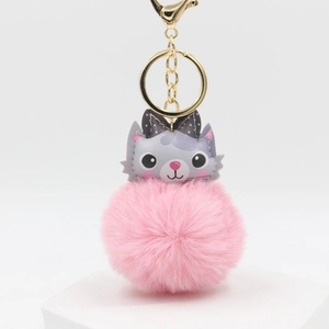 Pink cat plush pompom keychain with a polka dot bow tie on a white platform