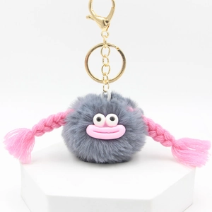 Detailed view of plush grey fur ball keychain with pink braided hair and metal clasp