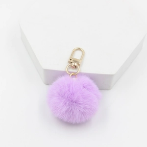 Soft light purple pom pom keychain with a gold spring hook on a white display block