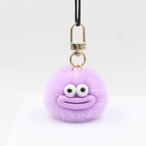 Cute purple plush monster keychain with large eyes and gold spring clasp on white background