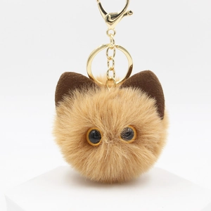 Detail of light brown plush cat keychain with golden metal ring and lobster clasp